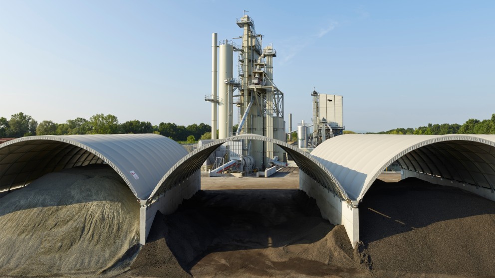 Roofs for dry storage of virgin mineral and recycling material save a large amount of fuel and therefore CO2 during drying and heating of the material.